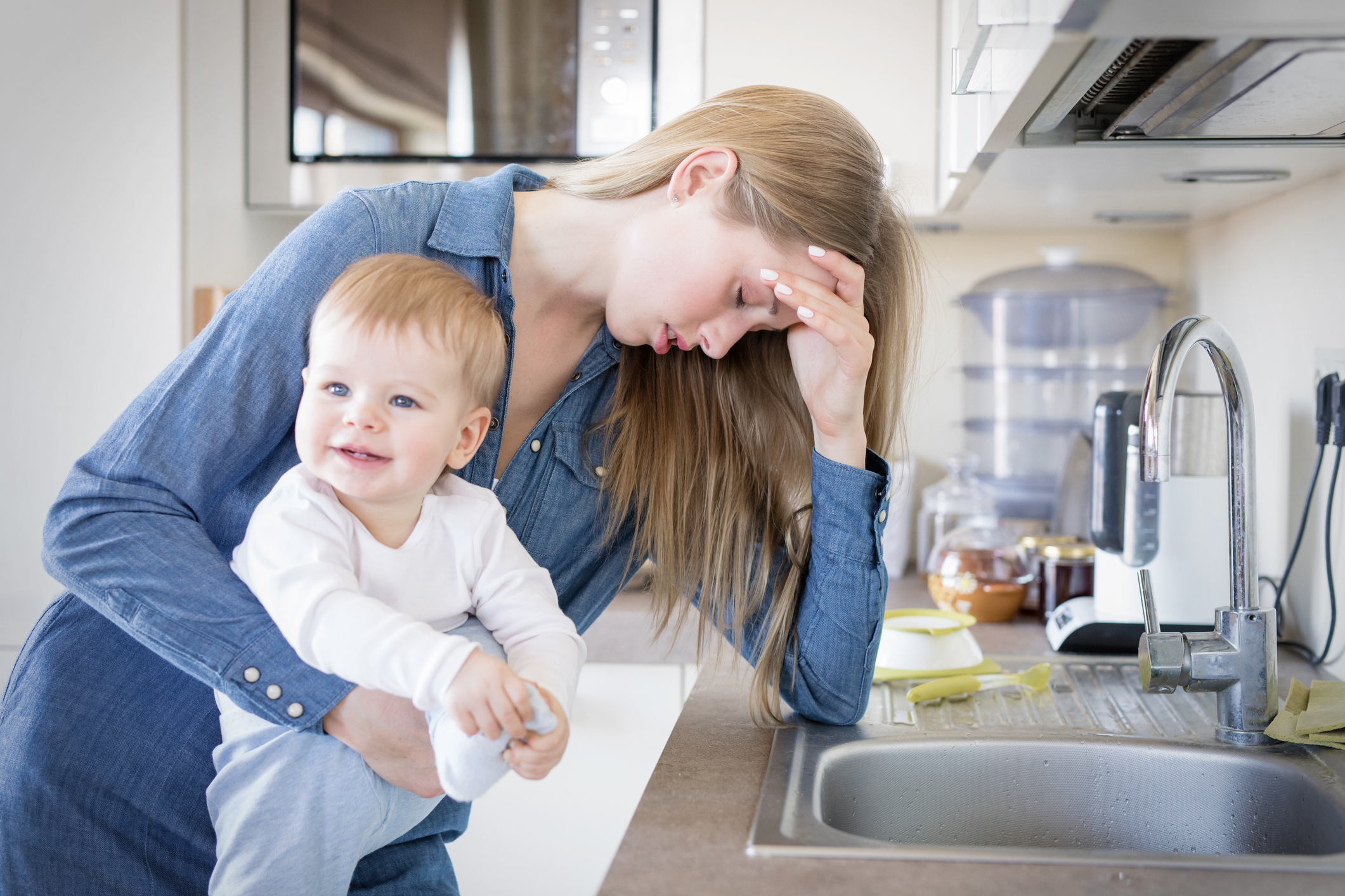 tired-mom-with-baby-in-her-arms-standing-by-the-sink-sensory-stepping